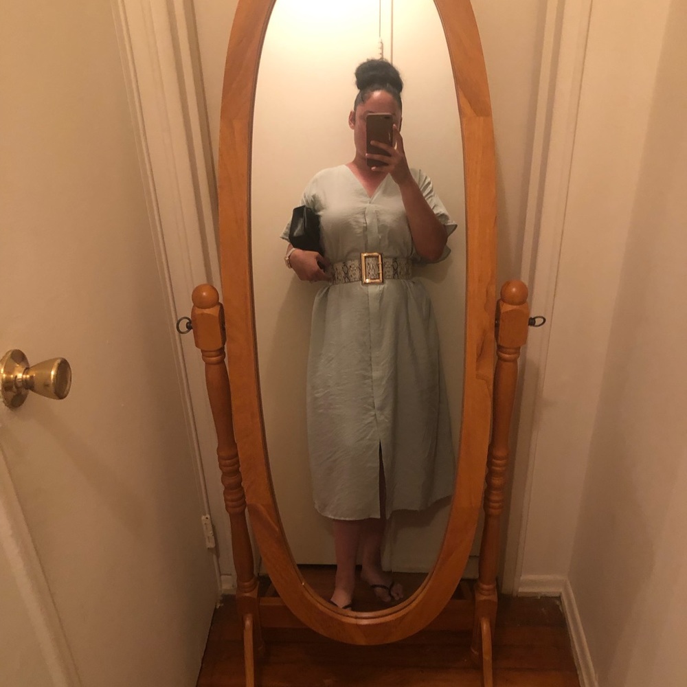 Light sage kaftan with snakeskin belt black clutch